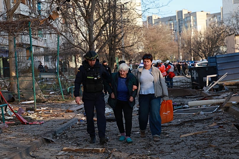 A rescuer helps an elderly woman to leave her home damaged by Russian aerial guided bomb in Zaporizhzhia, 14 March, 2026