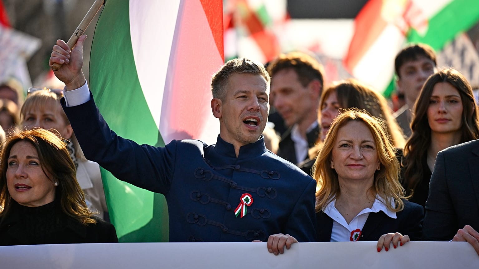 Opposition leader Peter Magyar, center, waves a flag during a march in Budapest, Hungary, Sunday, March 15, 2026. (AP Photo/Denes Erdos)