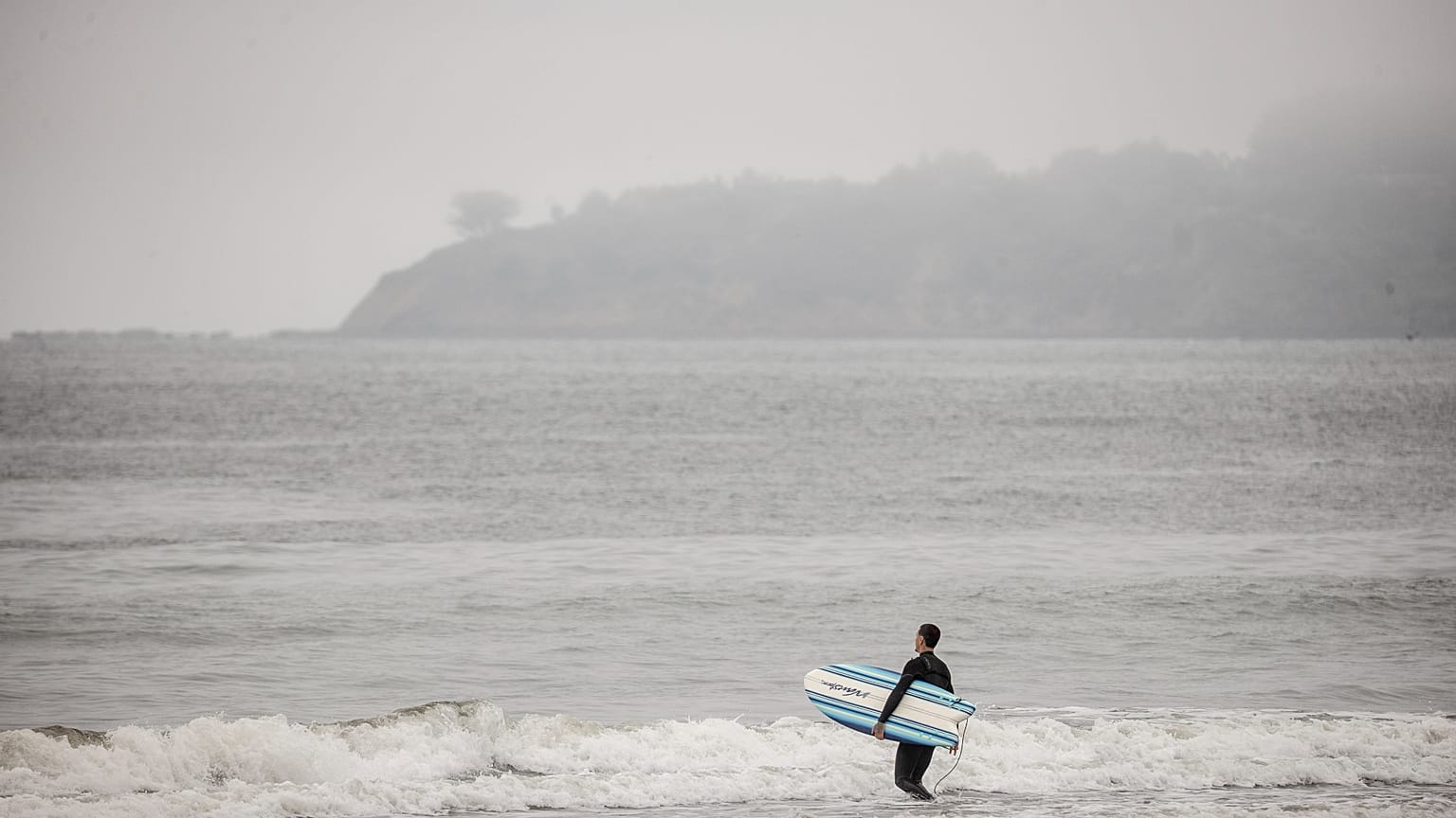 Серфингист катается на пляже Стинсон после снятия предупреждения о цунами в округе Марин, Калифорния, среда, 30 июля 2025 года.
