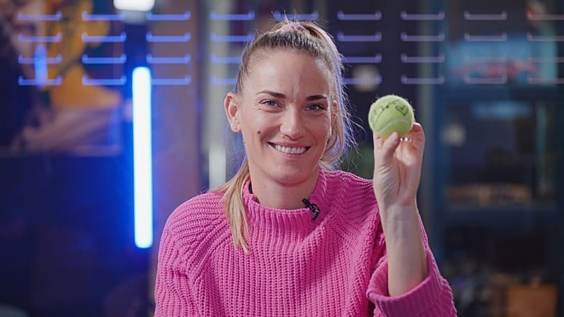 Babos Tímea egy általa aláírt teniszlabdával a kezében 