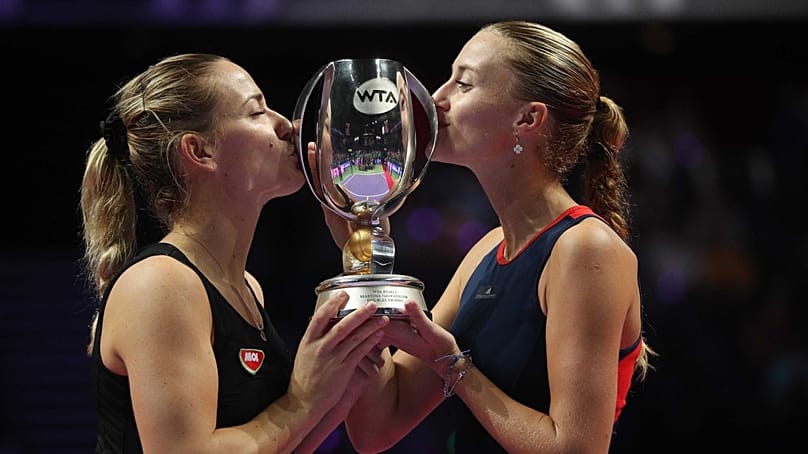 Babos Tímea (balra) és partnere, a francia Kristina Mladenovic megcsókolja a bajnoki trófeát, miután győztek a női tenisz-vb páros versenyének döntőjében 2018. október 28-án