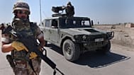 FILE: A Spanish soldier walks next to a Humvee during a join foot patrol with the new Iraqi army in Diwaniyah south of Baghdad, Iraq, 16 March 2004 