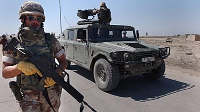 FILE: A Spanish soldier walks next to a Humvee during a join foot patrol with the new Iraqi army in Diwaniyah south of Baghdad, Iraq, 16 March 2004 