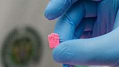 Ein Polizeibeamter hält eine einzelne MDMA-Tablette, auch bekannt als Ecstasy, während einer Medienpräsentation am Flughafen El Dorado in Bogota, Kolumbien, am Donnerstag, 22. Juni 2017.