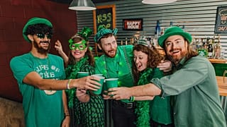 A group of people celebrating St. Patrick's Day in a pub. 