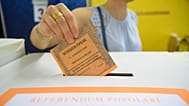 FILE: A woman casts her ballot in a box for referendums on citizenship and job protections, at a polling station in Milan, 8 June 2025