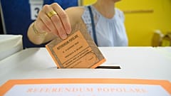 FILE: A woman casts her ballot in a box for referendums on citizenship and job protections, at a polling station in Milan, 8 June 2025