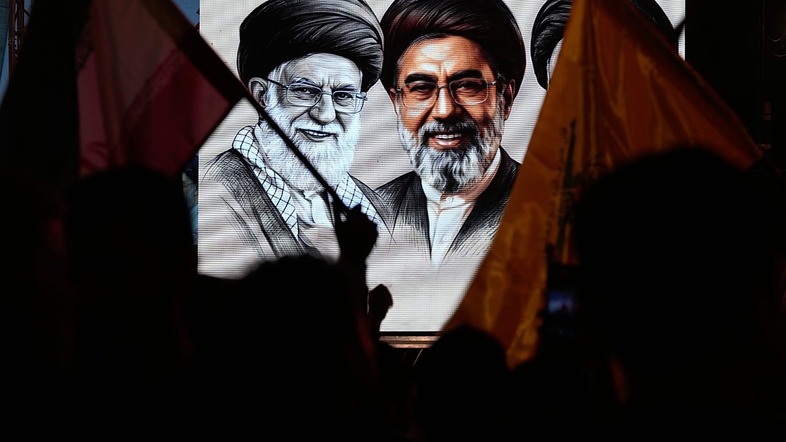 مسلمون شيعة يلوحون بالأعلام الإيرانية ويعرضون صور الزعيم الإيراني الراحل آية الله علي خامنئي وابنه آية الله مجتبي خامنئي