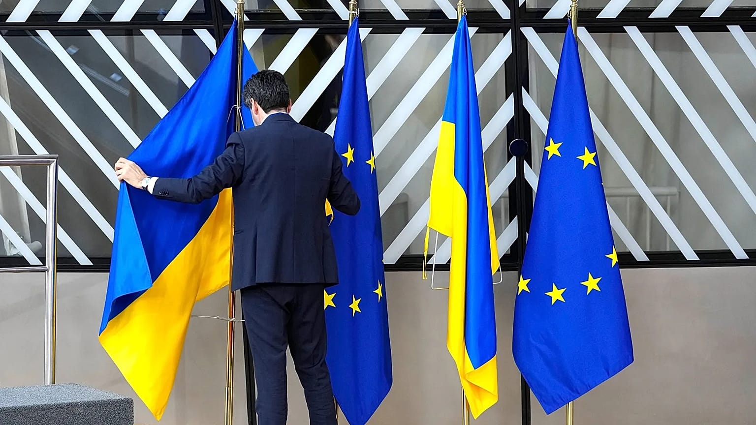 FILE: A member of protocol arranges the Ukrainian and EU flags during an EU summit at the European Council building in Brussels on Feb. 9, 2023