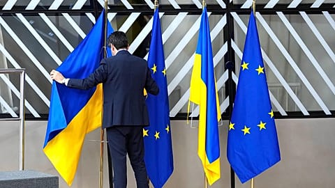 DATEI: Ein Mitglied des Protokolls ordnet die ukrainische und die EU-Flagge während eines EU-Gipfels im Gebäude des Europäischen Rates in Brüssel am 9. Februar 2023