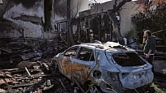 سكان يتفقدون منزلاً تضرر أمس جراء قذائف أطلقت من لبنان في نهاريا شمال إسرائيل