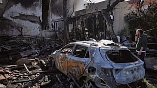 سكان يتفقدون منزلاً تضرر أمس جراء قذائف أطلقت من لبنان في نهاريا شمال إسرائيل