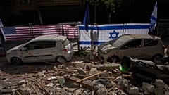 Israeli authorities hang Israeli and U.S. flags at the site struck by an Iranian missile that killed two people, in Ramat Gan, Israel, Wednesday, March 18, 2026.