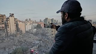 Mężczyzna nagrywa telefonem gruzy budynku zniszczonego w izraelskim ataku lotniczym w centrum Bejrutu w Libanie, w środę 18 marca 2026