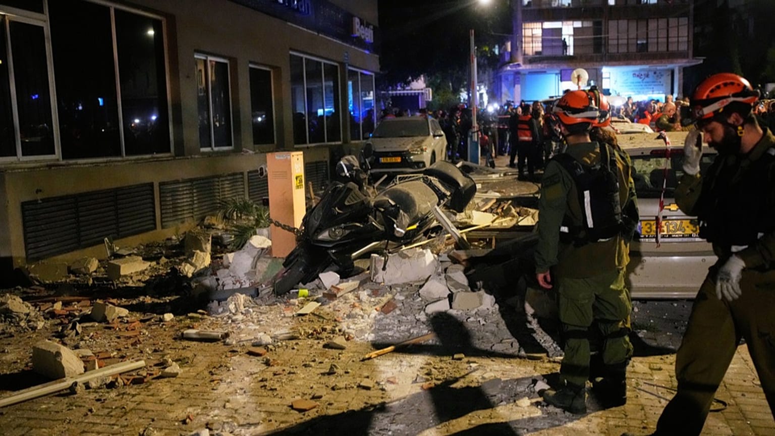 Israeli security forces inspect the site of an Iranian missile strike that killed two people in Ramat Gan, Israel, Wednesday, March 18, 2026