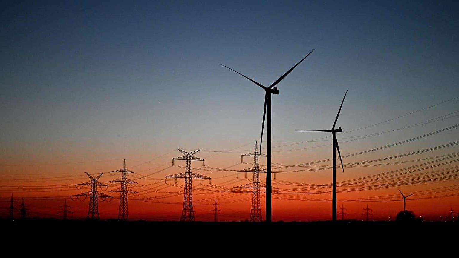 Turbinas eólicas num campo perto de Pulheim, na Renânia do Norte-Vestefália, Alemanha, após o pôr do sol de terça-feira, 3 de março de 2026.