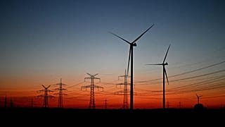 Wind turbines stand in a field near Pulheim, North Rhine-Westphalia, Germany, after sunset on Tuesday, March 3, 2026.