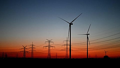 Wind turbines stand in a field near Pulheim, North Rhine-Westphalia, Germany, after sunset on Tuesday, March 3, 2026.