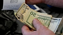 Ein Kunde greift nach seiner Quittung an einer Tankstelle in Portland, Oregon, USA, 16. März 2026