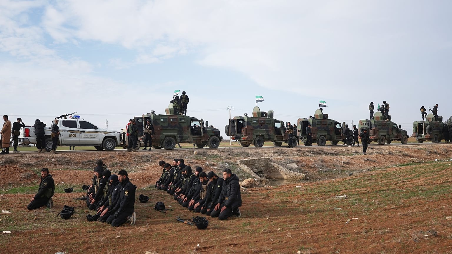 جنود يصلون على جانب الطريق بينما تتوقف قافلة من قوات وزارة الداخلية السورية أثناء توجهها إلى بلدة القامشلي شمال شرق سوريا، الثلاثاء 3 فبراير 2026.