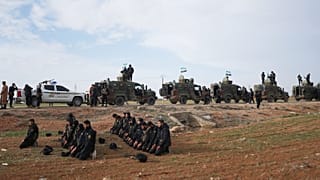 جنود يصلون على جانب الطريق بينما تتوقف قافلة من قوات وزارة الداخلية السورية أثناء توجهها إلى بلدة القامشلي شمال شرق سوريا، الثلاثاء 3 فبراير 2026.