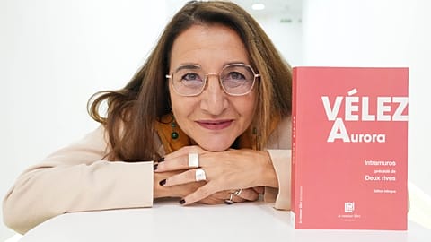 Aurora Vélez resting her chin on her hands posing with her book.