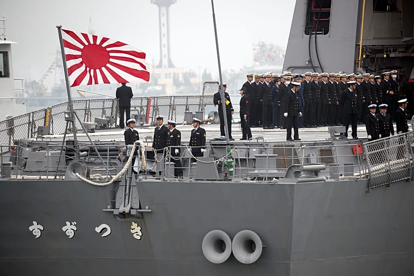 Sailors stand on deck of the Japanese destroyer Suzutsuki as it prepares to dock at a port in Qingdao in eastern China's Shandong Province. (AP Photo/Mark Schiefelbein)
