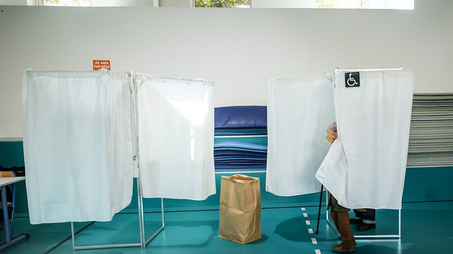 Des électeurs se tiennent dans les isoloirs lors du premier tour des élections municipales à Paris, le dimanche 15 mars 2026.