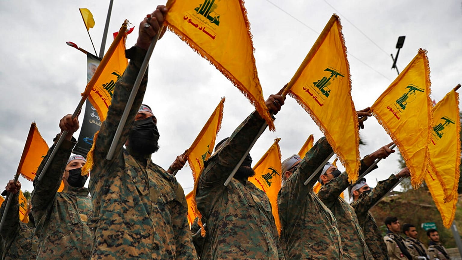 مقاتلون من حزب الله يرفعون العلم خلال مراسم إحياء الذكرى الثانية للقائد الإيراني قاسم سليماني، في الضاحية الجنوبية لبيروت، في 4 يناير 2022.
