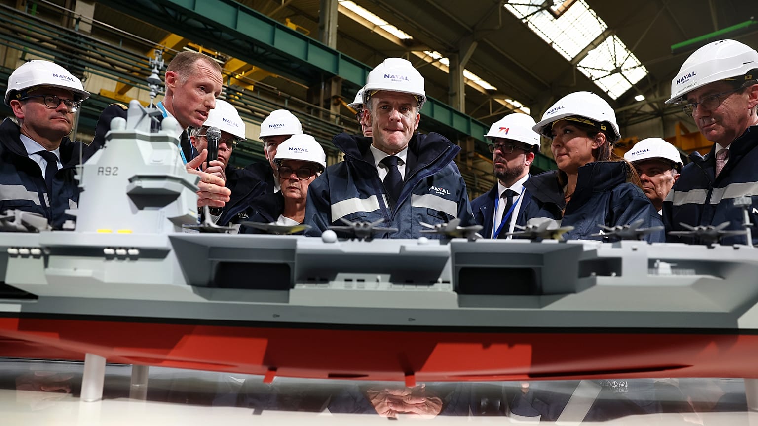 يقف الرئيس الفرنسي إيمانويل ماكرون، في الوسط، بجوار نموذج لسفينة تحمل اسم "فرانس ليبر"، خلال زيارته لموقع بناء مجموعة نافال جروب نانت-إندريه، حيث يجري بناء الجيل القادم من حام