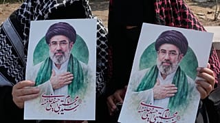 Women hold posters of the Iranian Supreme Leader Ayatollah Mojtaba Khamenei in downtown Tehran, 14 March, 2026