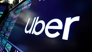 FILE - The Uber logo appears above a trading post on the floor of the New York Stock Exchange. 16 Aug. 2019
