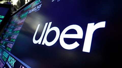 FILE - The Uber logo appears above a trading post on the floor of the New York Stock Exchange. 16 Aug. 2019
