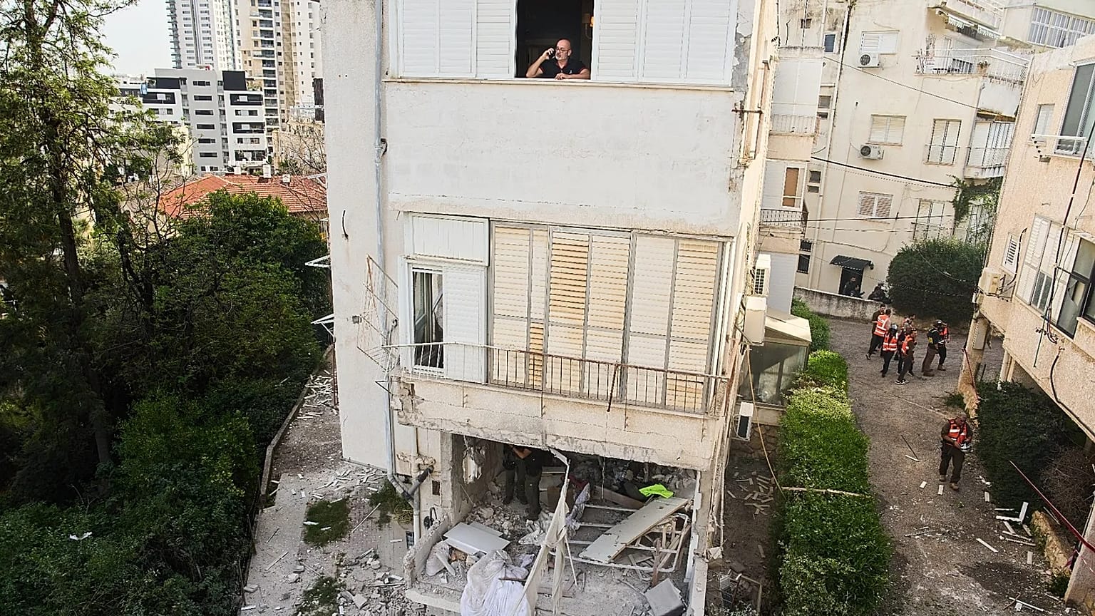 A man looks out from the window of an apartment building that was struck by an Iranian missile in Ramat Gan, Israel, Wednesday, March 18, 2026. (AP Photo/Oded Balilty)