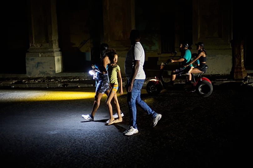People walk down a street during a blackout in Havana, 16 March, 2026
