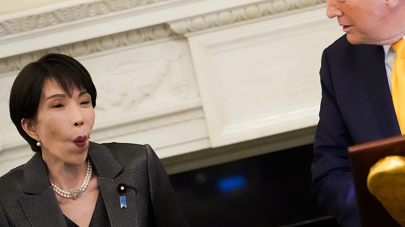 Sanae Takaicsi japán kormányfő reagál, miközben Donald Trump amerikai elnök beszél a Fehér Ház állami ebédlőjében tartott vacsorán