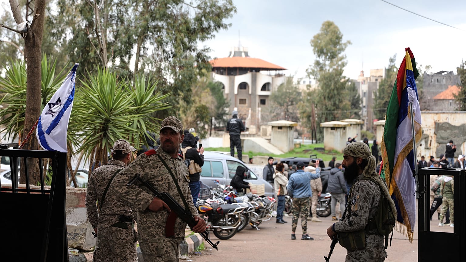 يقف مسلحون دروزيون حراساً لدى وصول السجناء بعد إطلاق سراحهم في عملية تبادل أسرى بين قوات الحكومة السورية وميليشيات دروزية في محافظة السويداء، سوريا، الخميس 26 فبراير/شباط 2026
