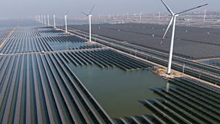 FILE - Wind turbines operate along a solar farm near Weifang in eastern China's Shandong province on March 22, 2024. 