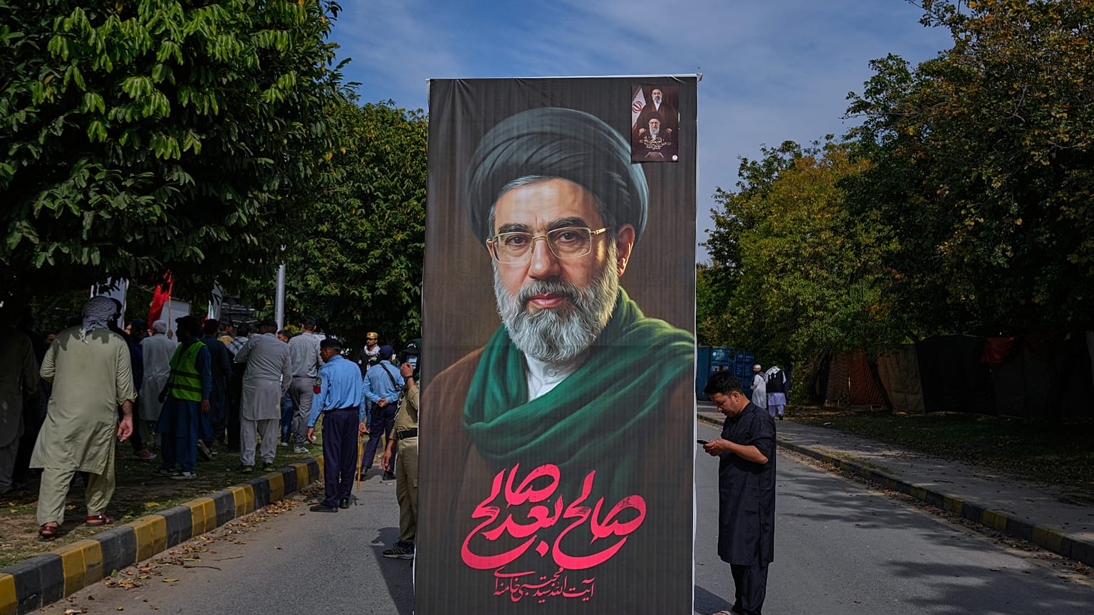 مسلم شيعي يسير حاملاً لوحة إعلانية ضخمة للمرشد الأعلى الإيراني آية الله مجتبى خامنئي خلال مسيرة يوم القدس 