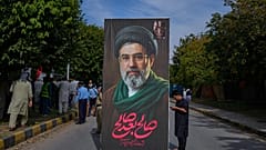 مسلم شيعي يسير حاملاً لوحة إعلانية ضخمة للمرشد الأعلى الإيراني آية الله مجتبى خامنئي خلال مسيرة يوم القدس 