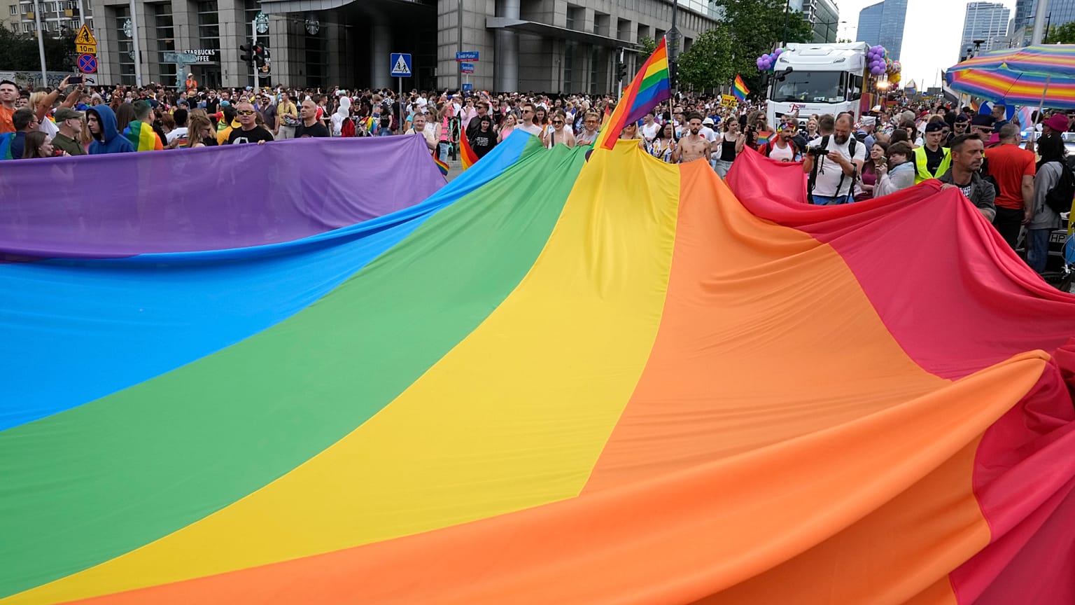 Ludzie niosą tęczową flagę podczas corocznej Parady Równości, znanej jako Parada Równości, w Warszawie, w sobotę 17 czerwca 2023 r.