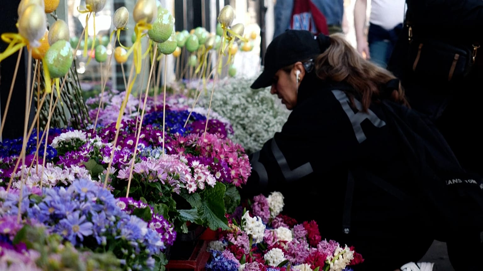A woman looks at flowers on display outside an Iranian shop on Ballards Lane, in the Finchley area of London