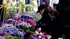 A woman looks at flowers on display outside an Iranian shop on Ballards Lane, in the Finchley area of London