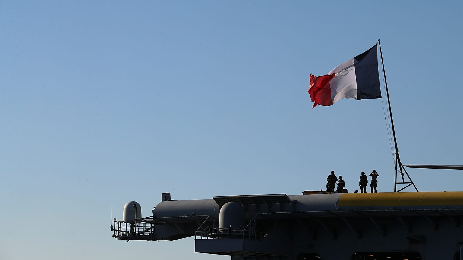 Des officiers de la Marine nationale française se tiennent à bord du porte-avions Charles de Gaulle, au large de la banlieue de Faliro, à Athènes, le jeudi 24 mars 2022.