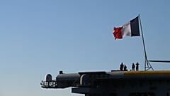 Oficerowie francuskiej marynarki wojennej stoją na pokładzie lotniskowca Charles de Gaulle na przedmieściach Faliro w Atenach, czwartek, 24 marca 2022 r.