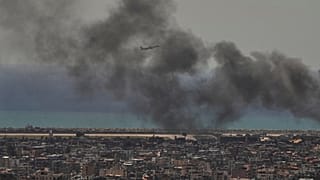 طائرة تابعة لشركة طيران الشرق الأوسط تقلع من مطار رفيق الحريري الدولي، فيما يتصاعد الدخان من موقع غارة إسرائيلية في الضاحية الجنوبية لبيروت، 17 مارس 2026.