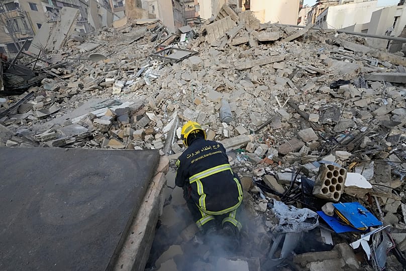 رجل إطفاء يتفقد مبنى دُمّر جراء غارة إسرائيلية في بيروت، 18 مارس 2026.