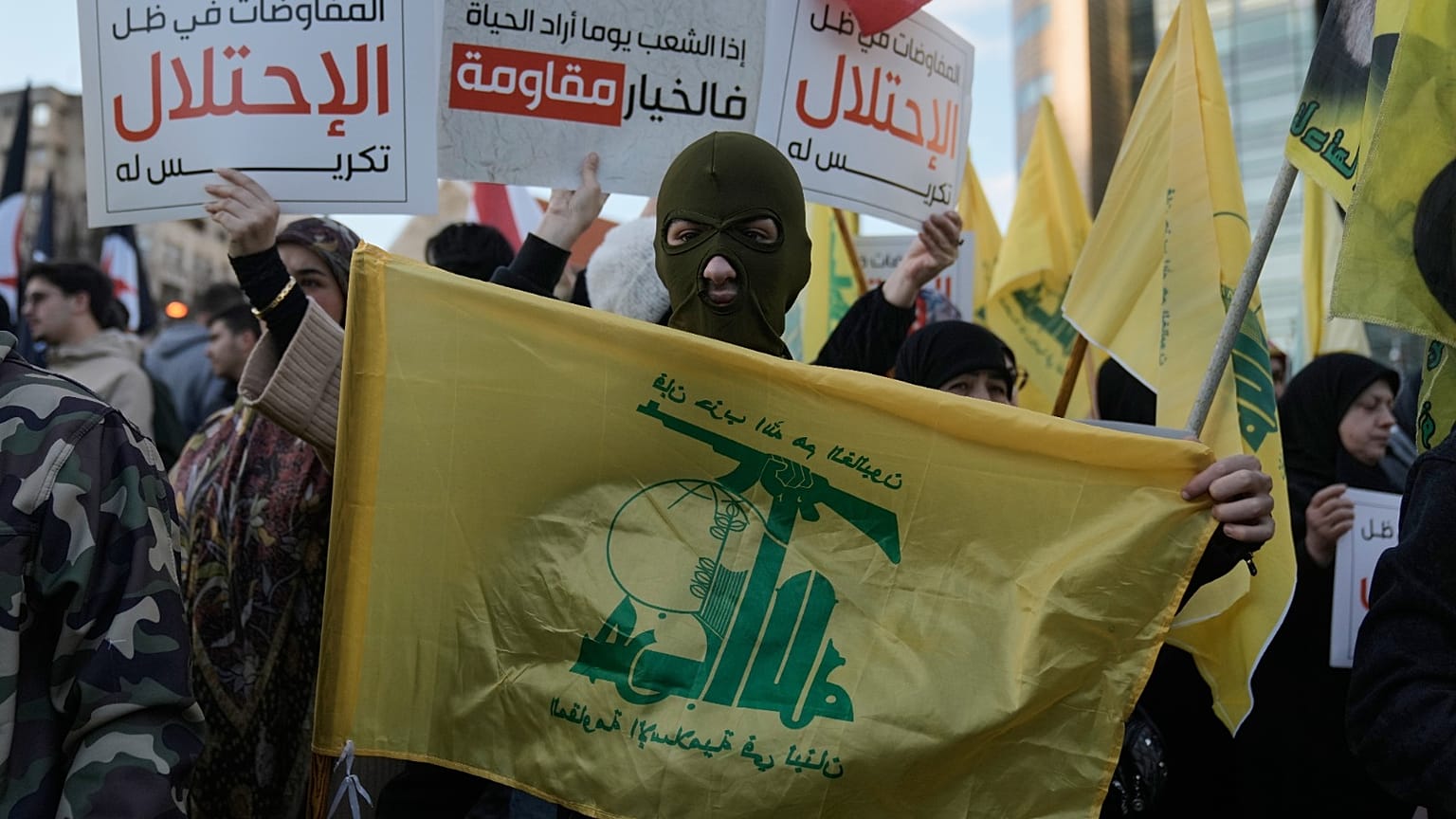 أحد أنصار حزب الله يحمل علم الجماعة خلال احتجاج يدين الأعمال العسكرية الإسرائيلية الأخيرة في لبنان 