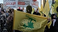 أحد أنصار حزب الله يحمل علم الجماعة خلال احتجاج يدين الأعمال العسكرية الإسرائيلية الأخيرة في لبنان 