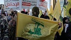 أحد أنصار حزب الله يحمل علم الجماعة خلال احتجاج يدين الأعمال العسكرية الإسرائيلية الأخيرة في لبنان 